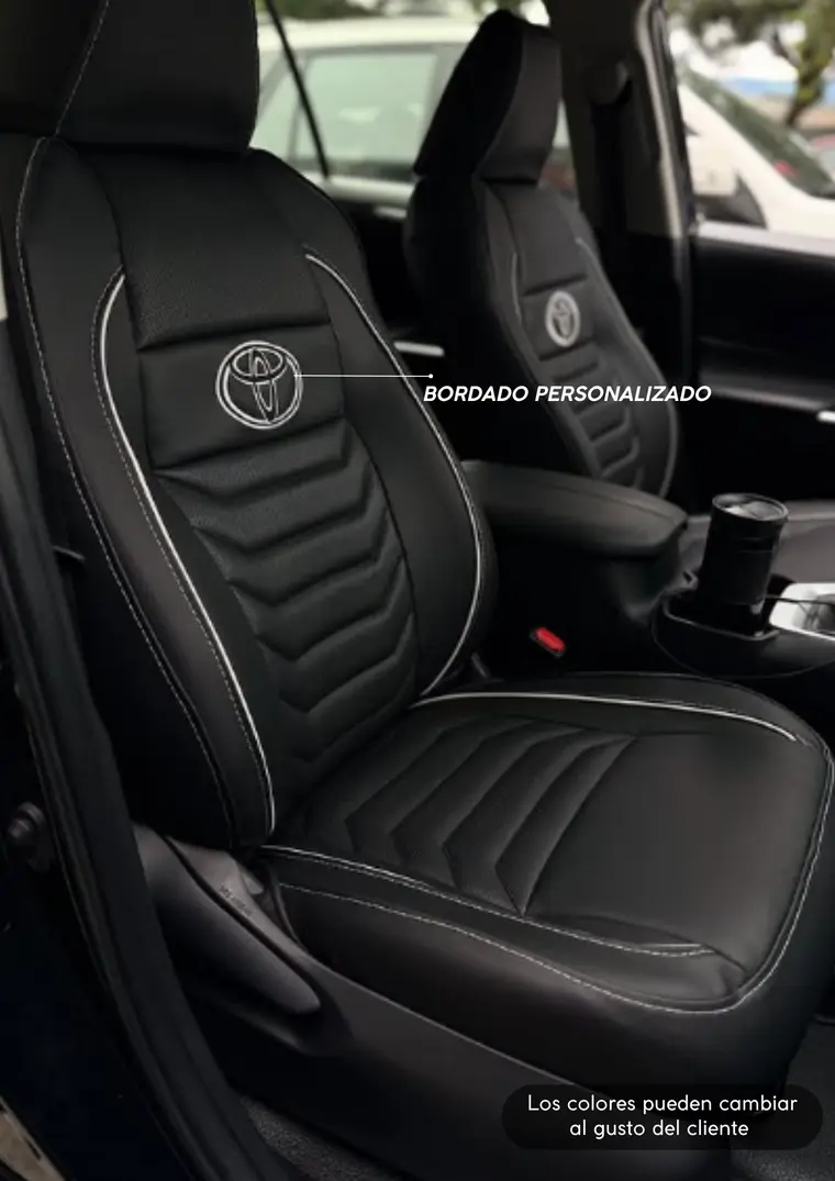 Forros de cuero negro con costura blanca y bordado Toyota en una camioneta