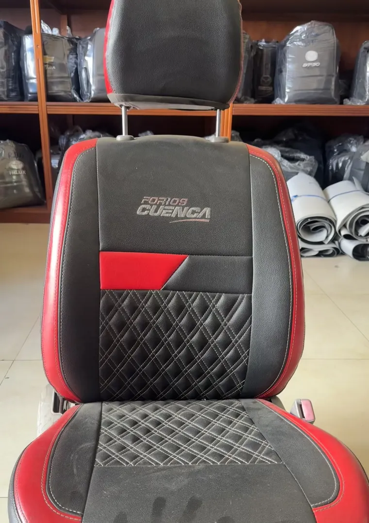 Asiento de exhibici&oacute;n de Forros Cuenca en cuero negro con rojo, capiton&eacute; de rombos y logo bordado